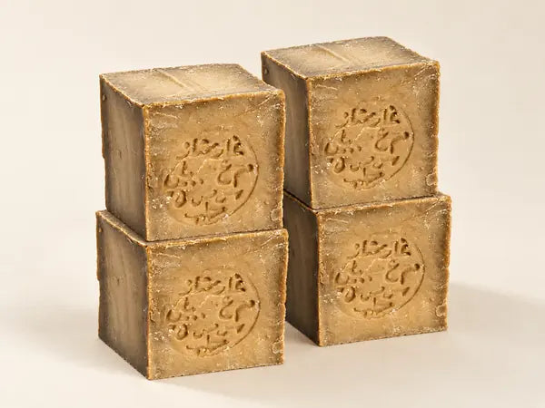 Four stamped bars of Aleppo soap stacked in two columns